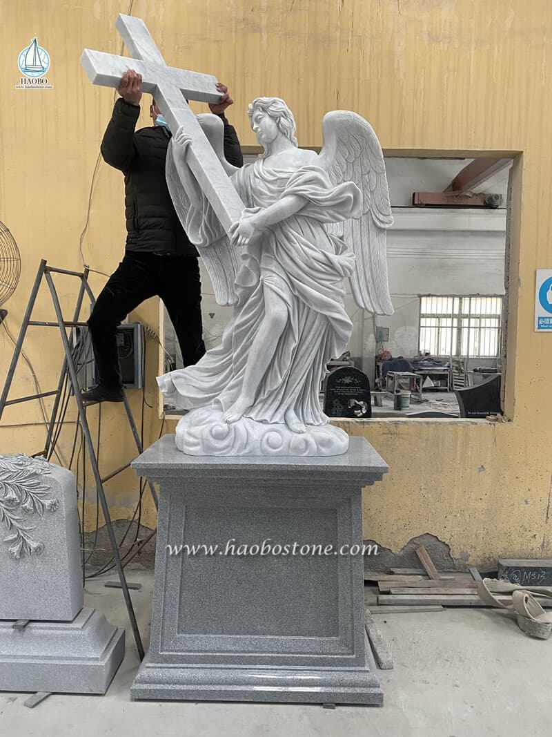 sculpture of angel holding cross